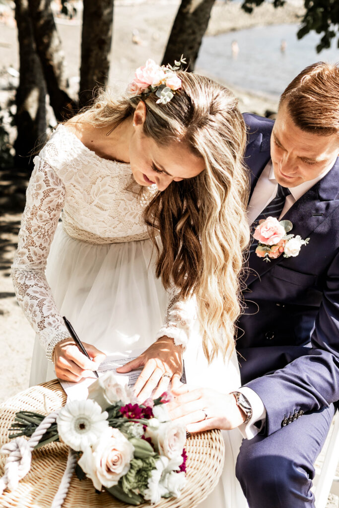 Bride and groom sign papers at this Whytecliff Park elopement