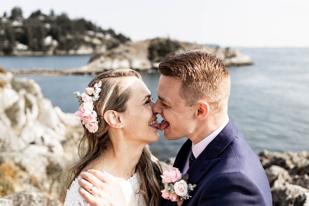 Bride and groom touch tongues at this Whytecliff Park elopement