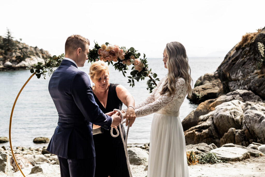 The couple participate in a hand fasting ceremony at their Whytecliff Park elopement