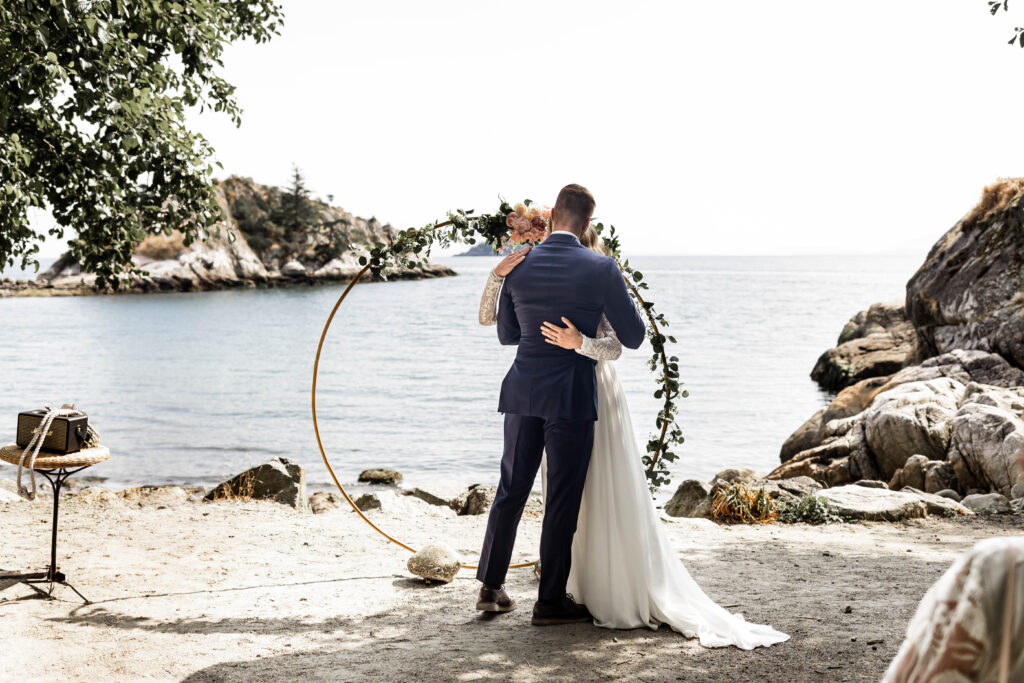 Bride and groom share a first kiss at their Whytecliff Park elopement