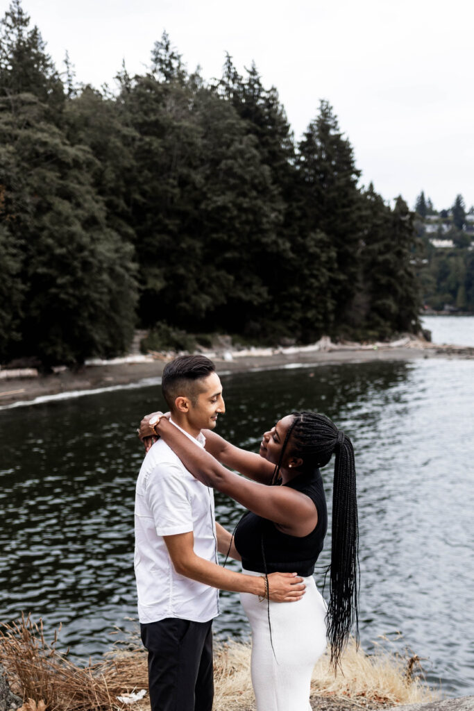 The couple dance together on a cliff at this Whytecliff Park engagement shoot