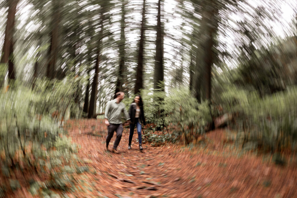 Walking through tranquil trails, a couple enjoys their engagement shoot at Lighthouse Park.