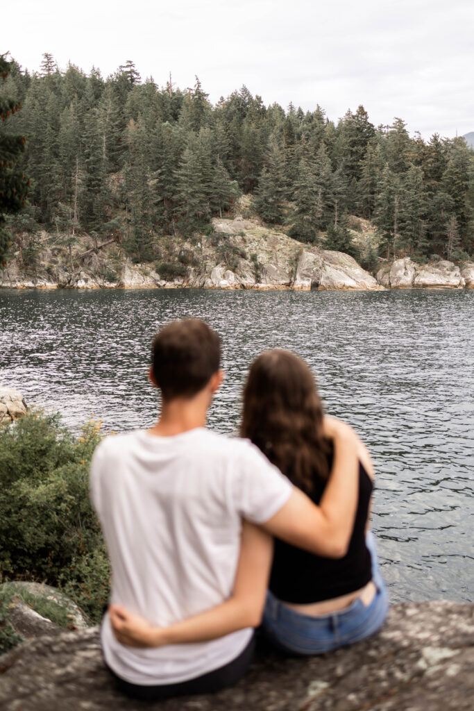 Couples admires the forest and ocean view at their Lighthouse Park Engagement Shoot