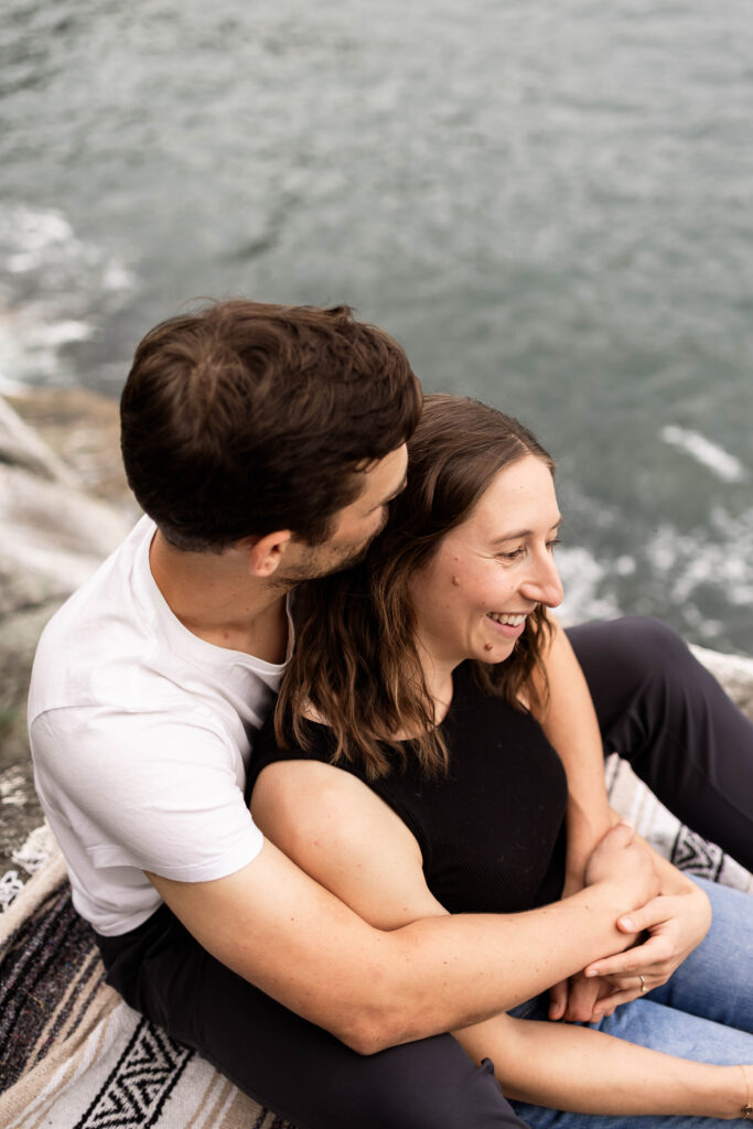 Ben and Stef sitting together at their Lighthouse Park Engagement Shoot