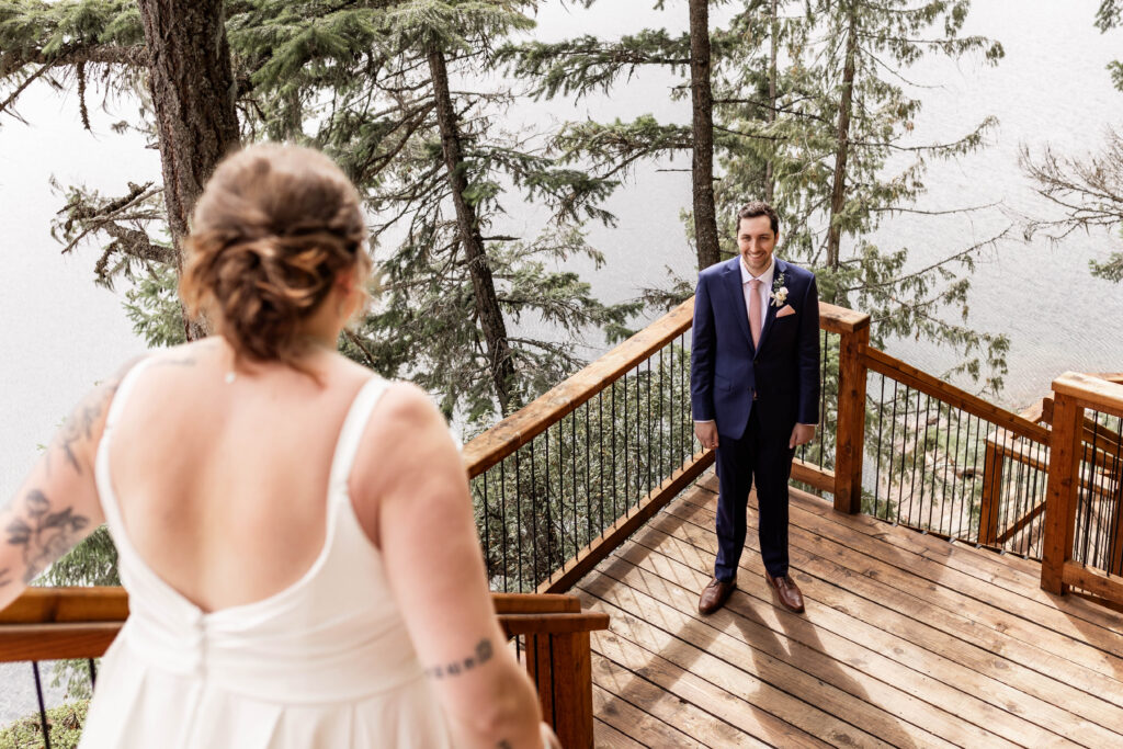 Bride walks down the stairs to greet her groom during a first look at their elopement overlooking Mabel Lake