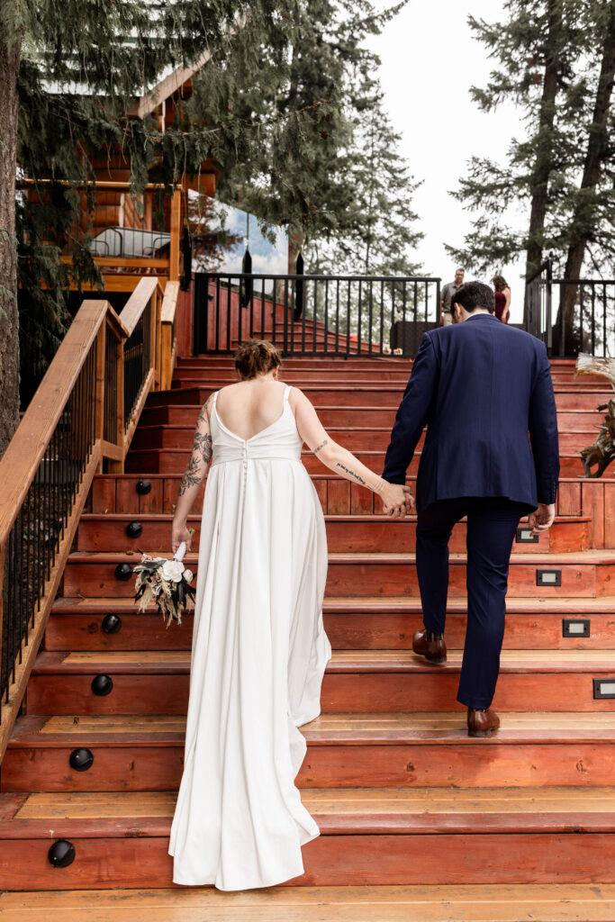 Bride and groom walk hand in hand to their elopement ceremony at Mabel Lake