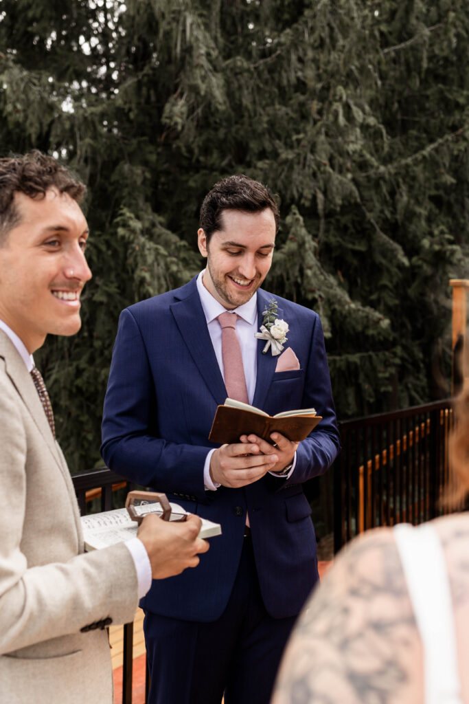 Groom smiles as he reads his vows to his bride at this Mabel Lake elopement