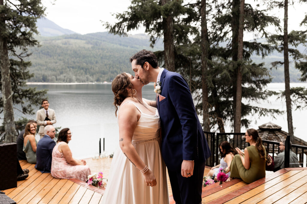 Bride and groom share a kiss at the end of the aisle at this Mabel Lake elopement