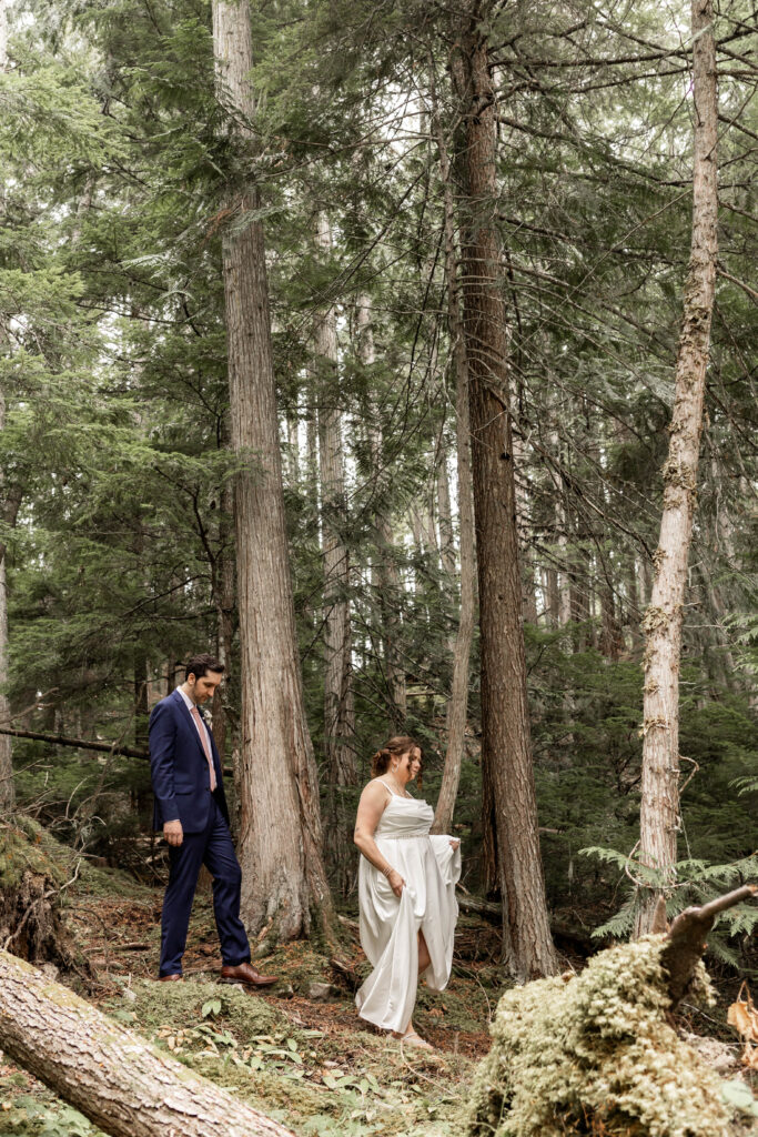 Bride and groom trek through the forest for their portraits at this Mabel Lake elopement