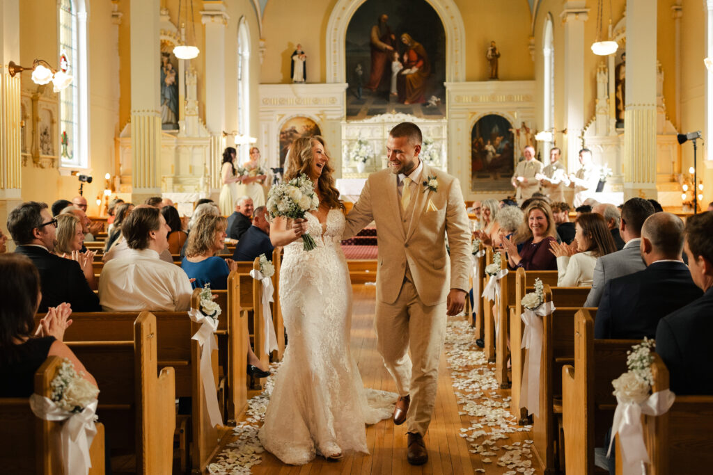 Couples laughs while walking back down the aisle at their Victoria cathedral wedding