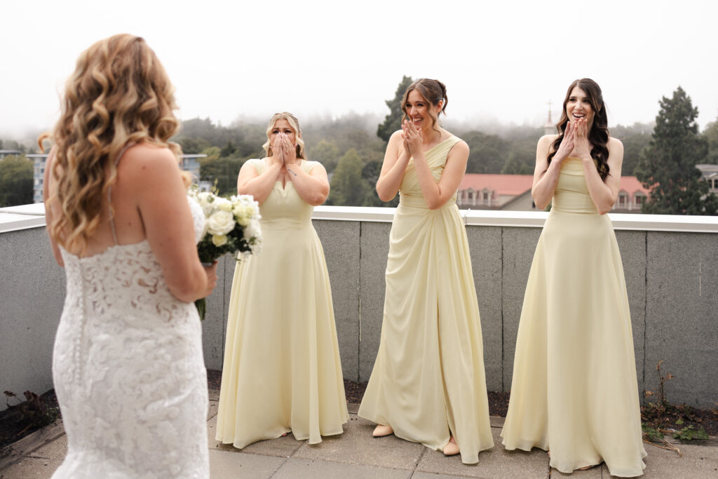 Brides first look with her bridesmaid on the deck of their room at Parkside Hotel in Victoria BC