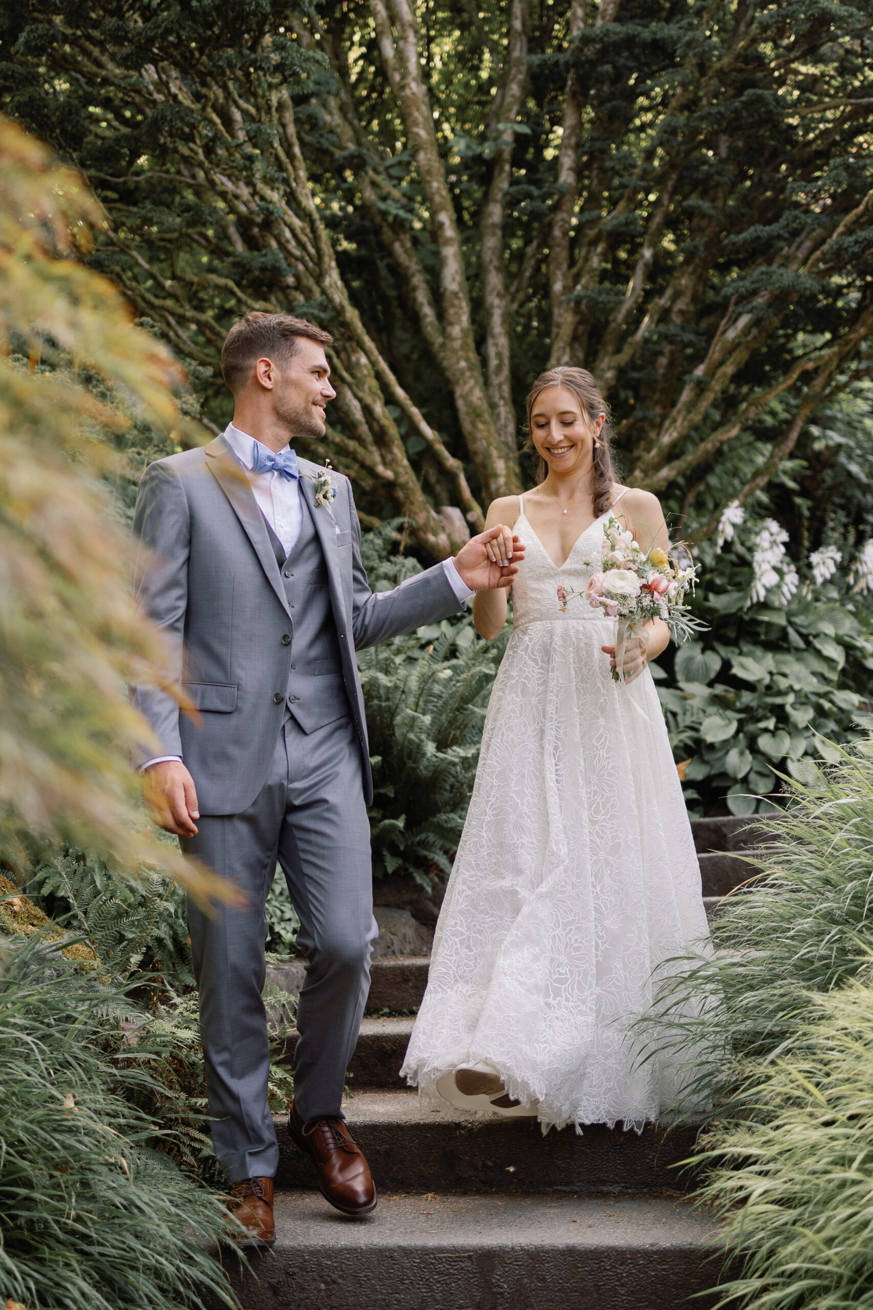 Bride and groom walking through gardens during Queen Elizabeth wedding portraits in Vancouver